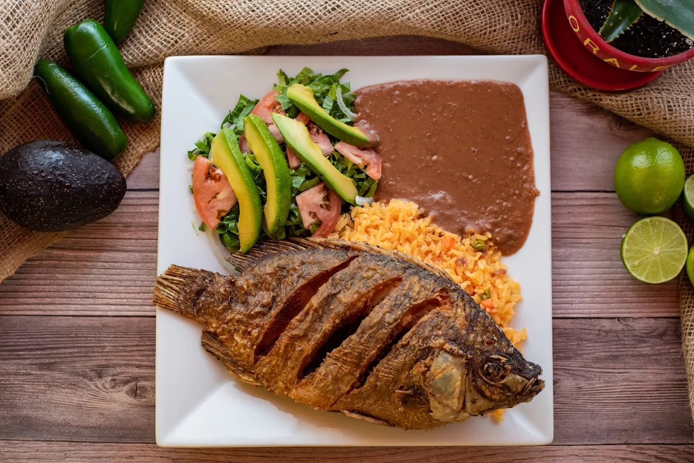 Whole fried tilapia with rice, beans and salad